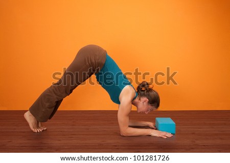 Fit woman practicing yoga with foam stability block