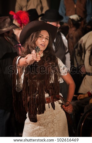 Sassy Latina woman in western outfit with pistol and dagger