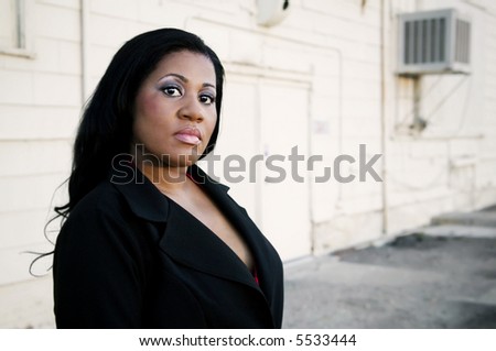 African America business woman in front of an industrial building.