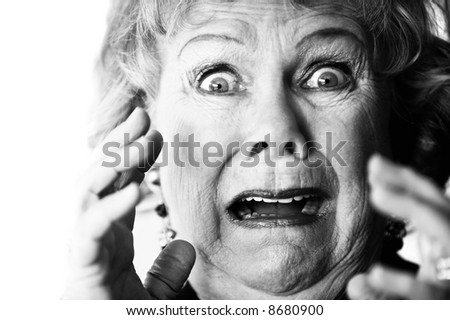 Close-up of a horrified senior woman with her mouth open.