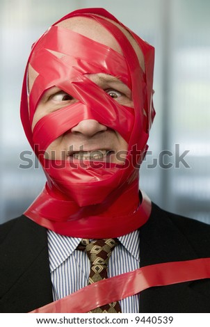 Cross-eyed businessman wrapped in red tape