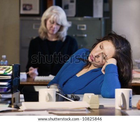 Hispanic woman sleeps at her office desk