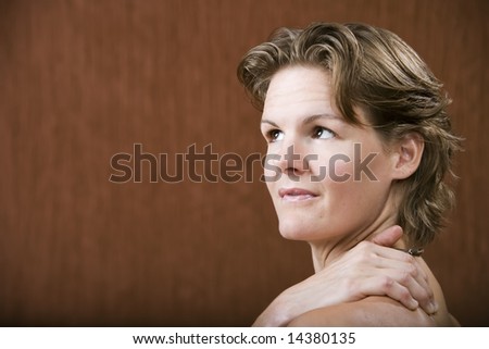 Woman with her hand on her shoulder looking left