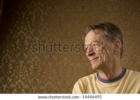 Senior Man Against a Gold Background Looking Left