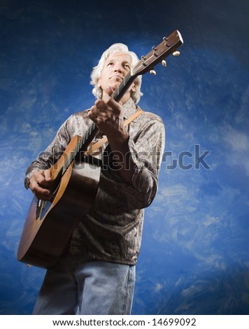 Guitarist with his Instrument in front of a Blue Wall