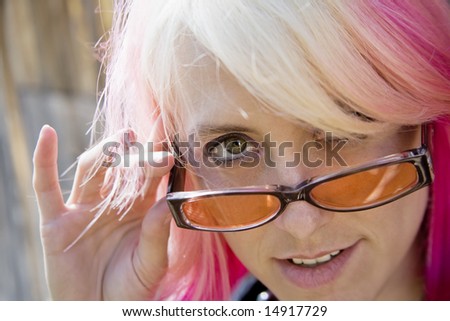 Pretty Young Woman with Brightly Colored Hair Looking Over the Top of her Sunglasses