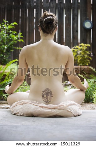 stock photo : Back of a nude woman with a Yoga tattoo meditating