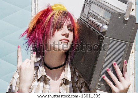 Punk girl with brightly colored hair sitting on trailer step holding boom box