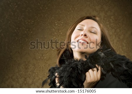 Pretty Hispanic Woman Wearing a Feather Boa in front of Gold Wallpaper