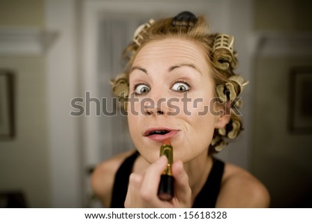 Woman in Curlers Applying Bright Red Lipstick