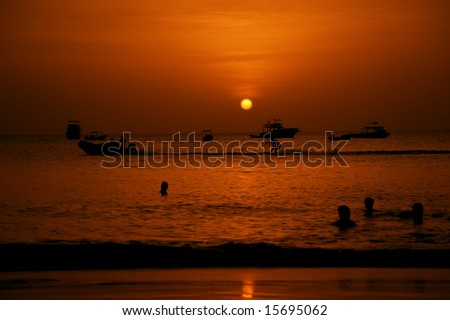 Swimmers and water skier in the Pacific Ocean at sunset