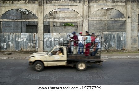 Truck full of people drives by abandoned building in Granada Nicaragua