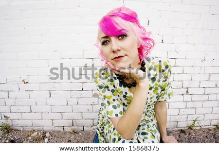 Woman with pink hair wearing polka dot dress in alley