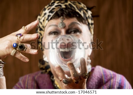 Female gypsy fortune teller holding a crystal ball to her eye