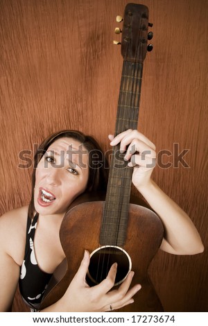 Wide-angle shot of a funny Hispanic folk singer with guitar