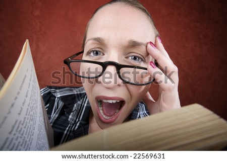 Screaming woman with big eyes and glasses reading a book.