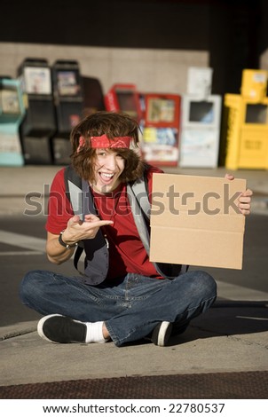 Young Man on Street Corner with Blank Cardboard Sign