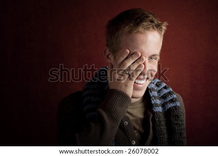 Young man covering face with his hand