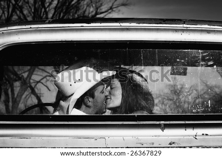 Cowboy kissing woman in pickup truck