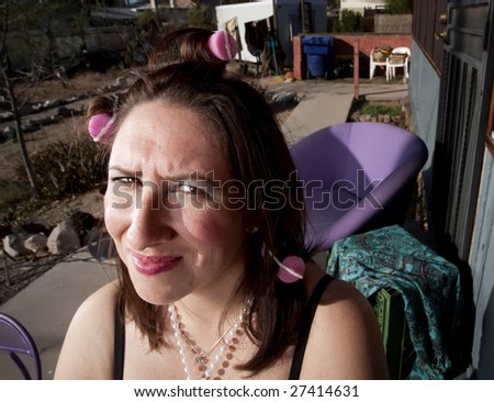 Hispanic woman in front of house with messy yard