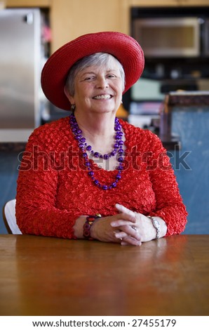 Friendly senior woman wearing a red hat