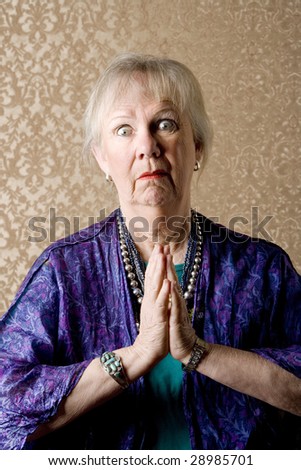 Funny senior new age lady in purple praying