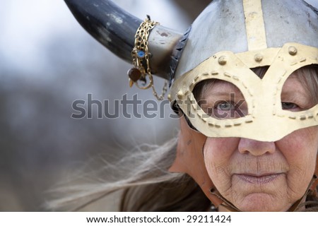 Closeup portrait of Viking woman in helmet with horns