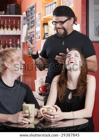 Three friends laughing together in a coffee house