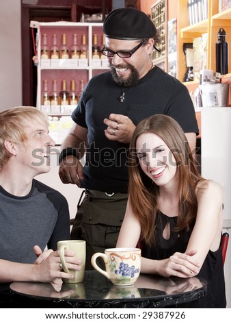 Three friends laughing together in a coffee house