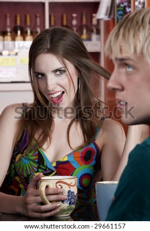 Woman flirting with male friend in a coffee house