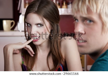 Woman flirting with uninterested male friend in a coffee house