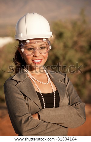 Pretty young woman in hard hat and safety goggles