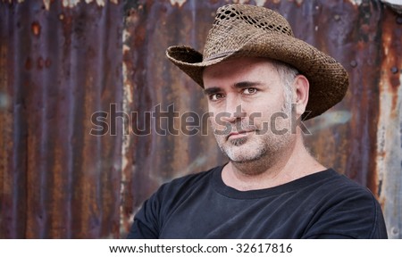Mature man with gray stubble in a cowboy hat