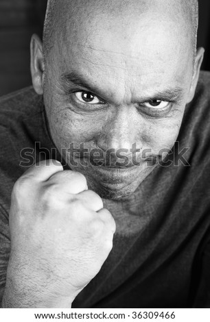 Angry man with shaved head making a fist