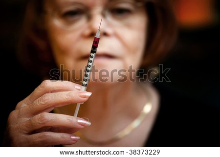 Senior woman looking at small hypodermic needle