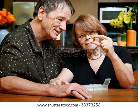 Senior couple at table with daily health supplements