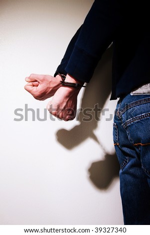 Young man with hands cuffed behind his back