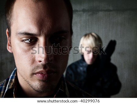 Frightened man being followed by young male criminal