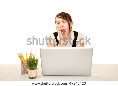 Bored female office worker at her desk with computer