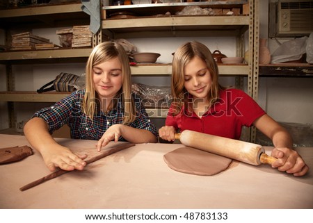 Cute young girls working on projects in a clay studio