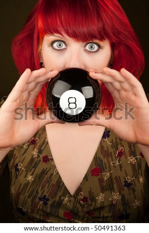 Pretty punky girl with brightly dyed red hair with prediction ball