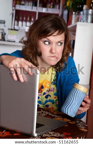 Paranoid lady at cafe with laptop and coffee