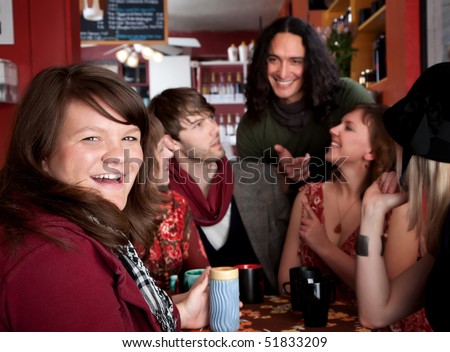Girl smiling at table with friends in coffee house