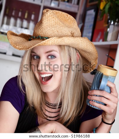 Young blond girl with cowboy hat and coffee