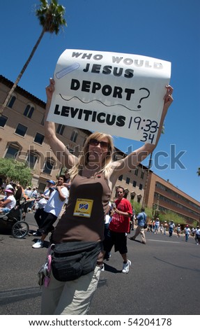 PHOENIX, AZ - MAY 29: Woman with sign citing Leviticus at SB1070 protest rally.  May 29, 2010 in Phoenix, AZ.