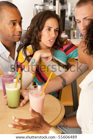 Two couples at a cafe drinking frozen beverages. Vertical shot.