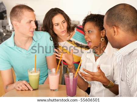 Two couples at a cafe drinking frozen beverages. Horizontal shot.