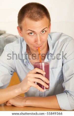 A young man drinking a frozen beverage. Vertical shot.
