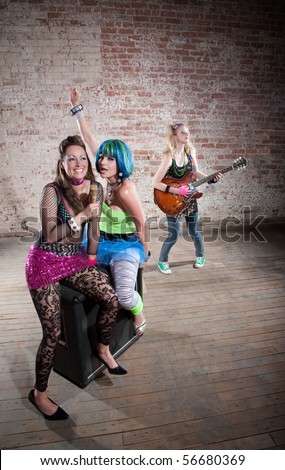 Young all girl punk rock band performs in a warehouse