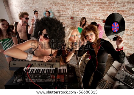 stock photo Cool female DJs performing at a 1970s Disco Music Party